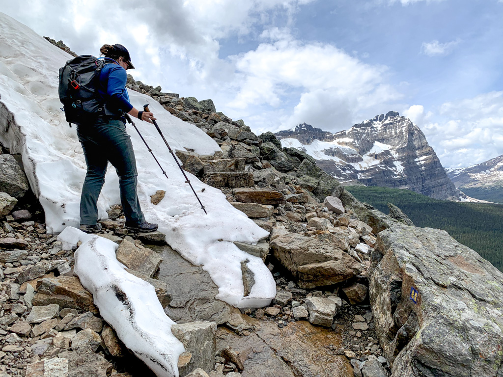 A woman walks through snow on the All Soul's Route. She knew how to find trail conditions so she is prepared with hiking poles