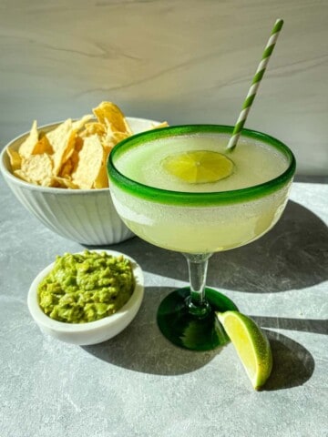 Minute Maid limeade margarita on a table with chips and guacamole.