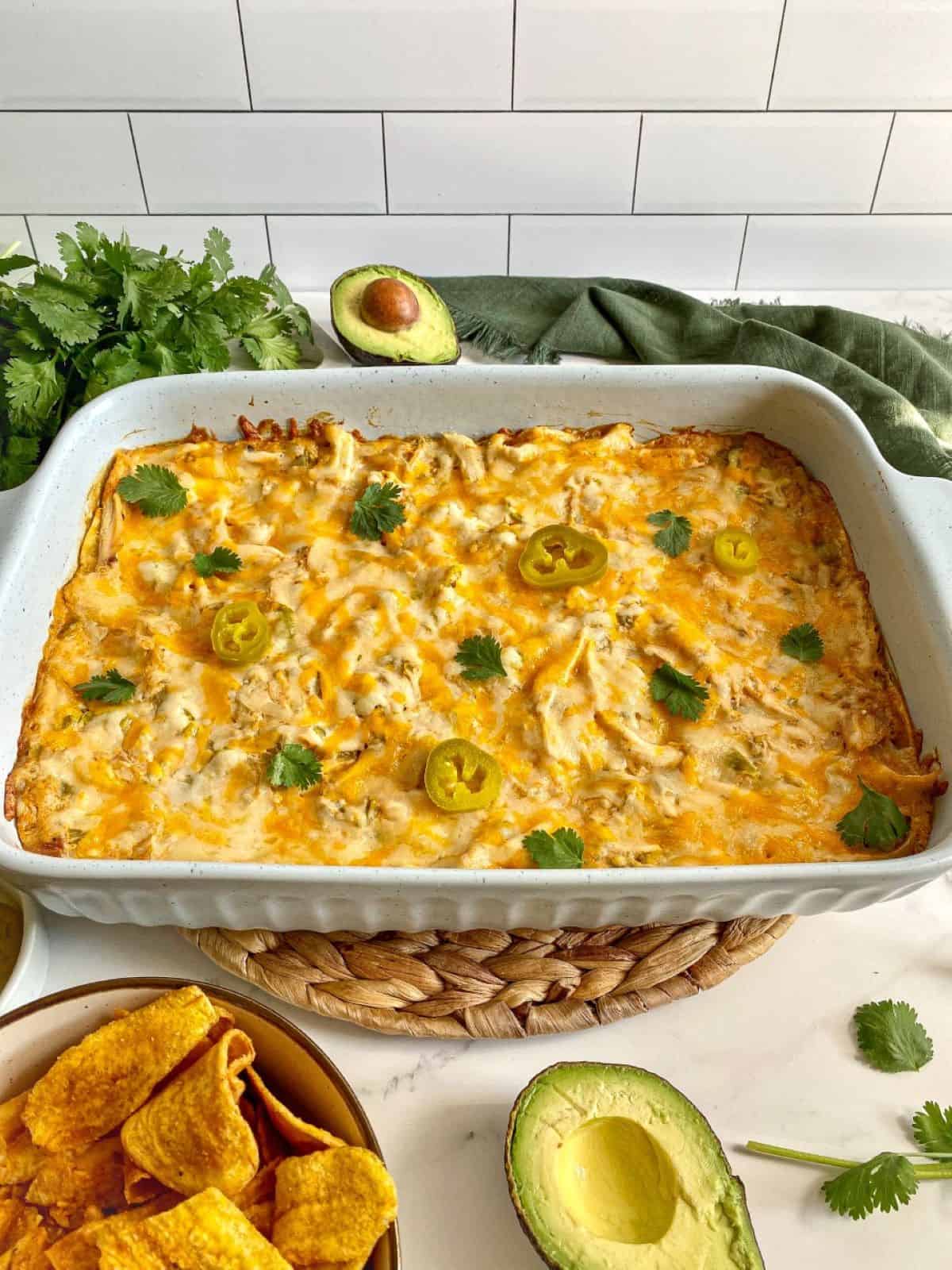 Tex Mex casserole in a large baking dish with melted cheese and jalapeno peppers on top.