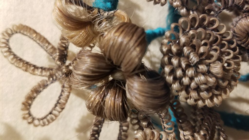 A bunch of hair is curled and has blue beads.