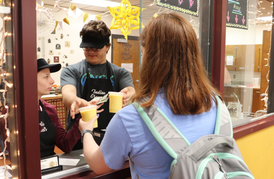 Junior Delaney Maier purchases a smoothie from the Helping Hands café, Indian Grounds.  "I really like going to Indian Grounds because even though I'm not a coffee-drinker, they have other options like the smoothies," Maier said. "It's also nice knowing my money is going to fund a student-run organization." Indian Grounds is open  between 7:15-7:56 a.m on Maroon days in the library.