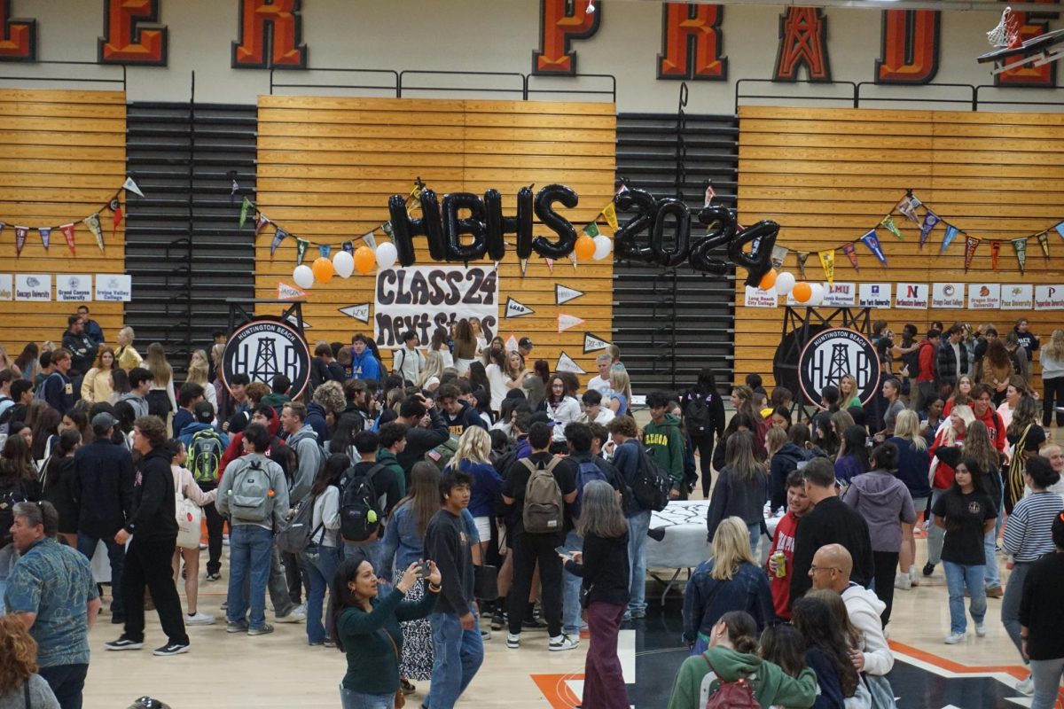 Seniors and their families socialize near the "HBHS 2024" balloon arch.