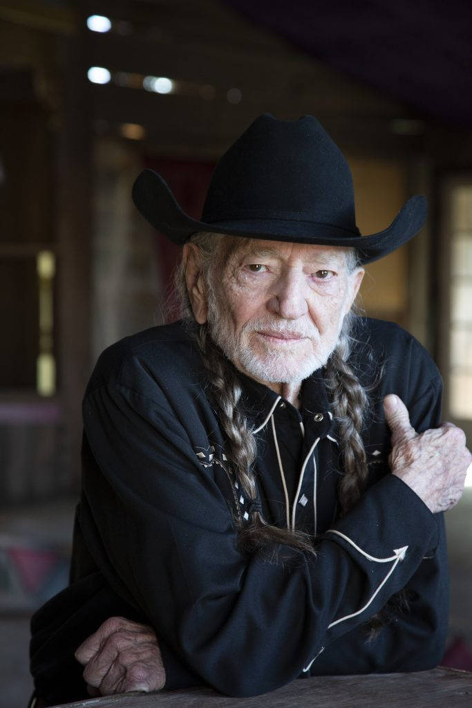 Legendary Musician Willie Nelson In Classic Black Attire Wallpaper