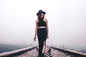 A Confident Young Woman Stands In The Middle Of A Empty Train Railway Wallpaper