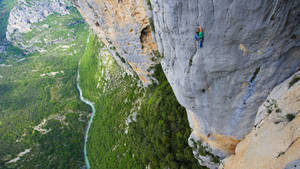 Aerial View Of Man Rock Climbing Wallpaper