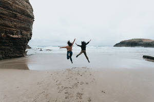 Beach Jumping Together Wallpaper