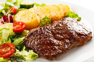 Caption: Mouthwatering Steak Parrilla With Fresh Veggies Wallpaper