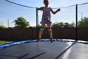 Kid Jumping On A Trampoline Wallpaper