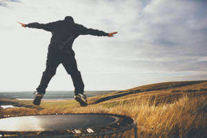 Man Jumping In Trampoline With View Wallpaper