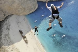 men, Sports, Jumping, Birds eye view, Sand, Helmet, Beach, Sea, Rock, Boat, Shipwreck, Sunlight, Greece, Parachutes