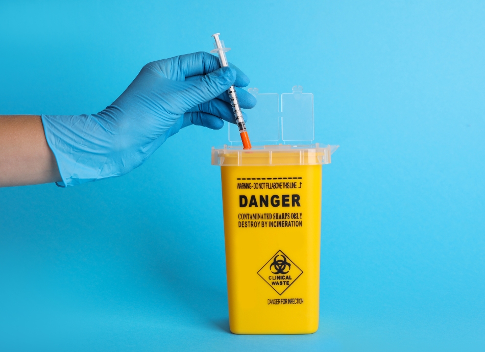 Syringe being put into sharps container