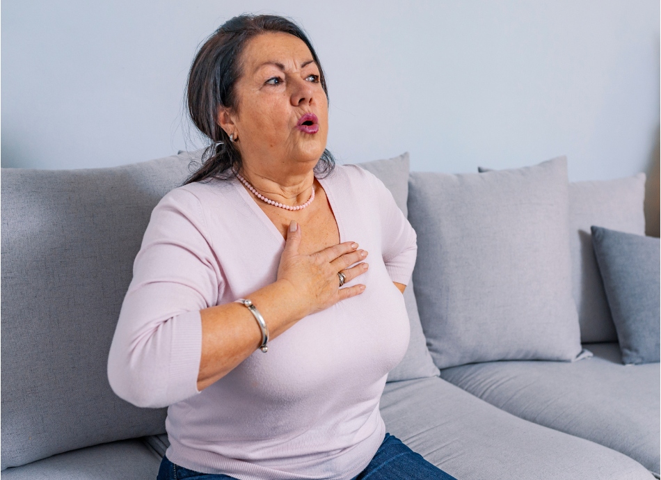 Breathless woman sitting with hand on chest