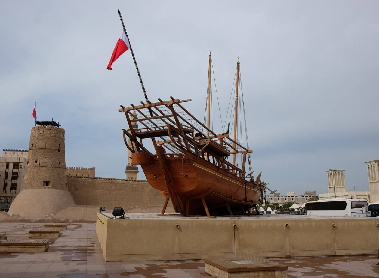 A huge dhow sailing ship in front of the Al Fahidi fort