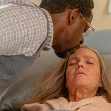 A man (Sterling K. Brown as Randall) kissing the forehead of a woman (Mandy Moore as Rebecca) who's in bed.