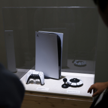 A PlayStation 5 (PS5) video game console and a controller at the Sony Group Corp. booth at the Combined Exhibition of Advanced Technologies 