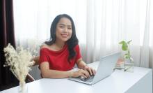 Woman in red dress working in an office.