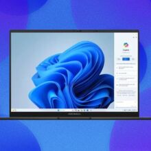 An Asus Zenbook laptop appears on an abstract bubble blue background with a plume of blue appearing on the screen.