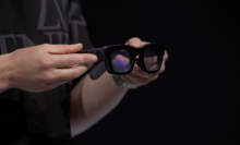 Pair of augemented glasses being held by hands