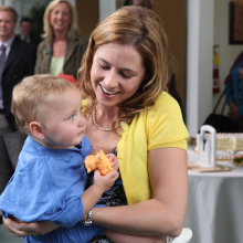 A woman holding a baby girl and smiling.