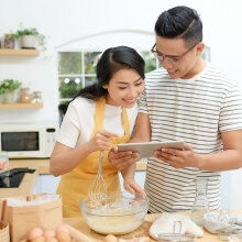 Two people looking at a tablet.