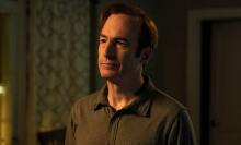 A man (Bob Odenkirk as Jimmy McGill) standing in a dimly lit living room.