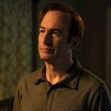 A man (Bob Odenkirk as Jimmy McGill) standing in a dimly lit living room.