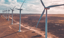 Wind turbines lined up on a vast field. 