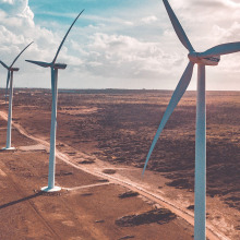 Wind turbines lined up on a vast field. 