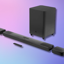 The JBL Bar 9.1 channel soundbar with detachable wireless speakers and a subwoofer, laid out on a gradient blue and purple background.