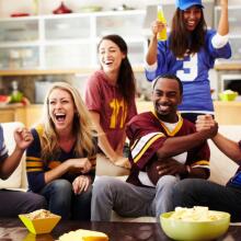 Friends watching football in living room 