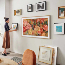 woman hanging Samsung The Frame tv on wall