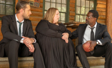 A man (Justin Hartley as Kevin), a woman (Chrissy Metz as Kate), and another man (Sterling K. Brown as Randall) sitting together on the step of a cabin.