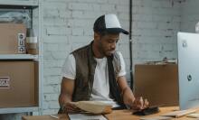 man looking at boxes in front of computer