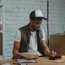 man looking at boxes in front of computer