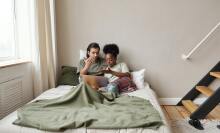 Couple watching laptop on bed