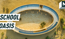 Aerial shot of the oval school amid the desert, solar panels seen on the roof. Caption reads:  school oasis