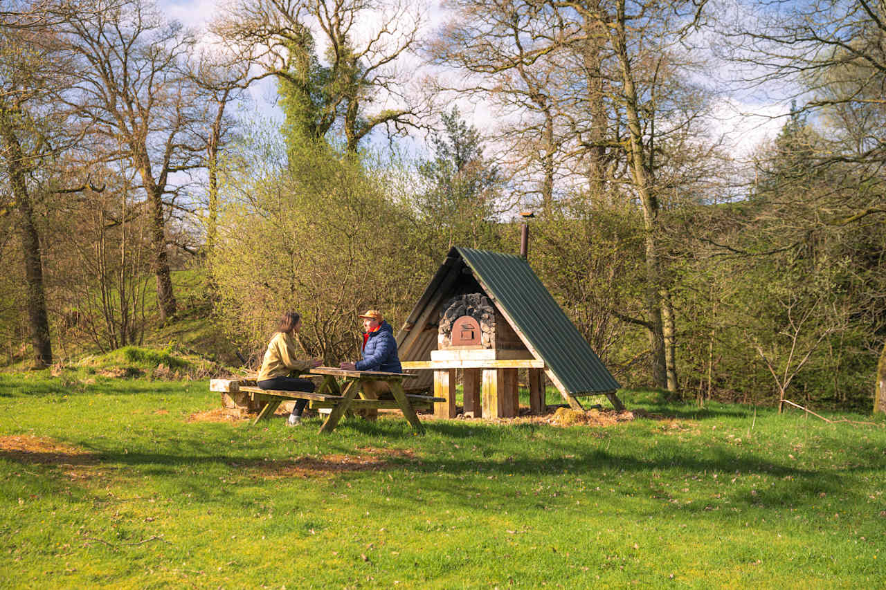 BBQ and outdoor seating in the woodland area of the campsite