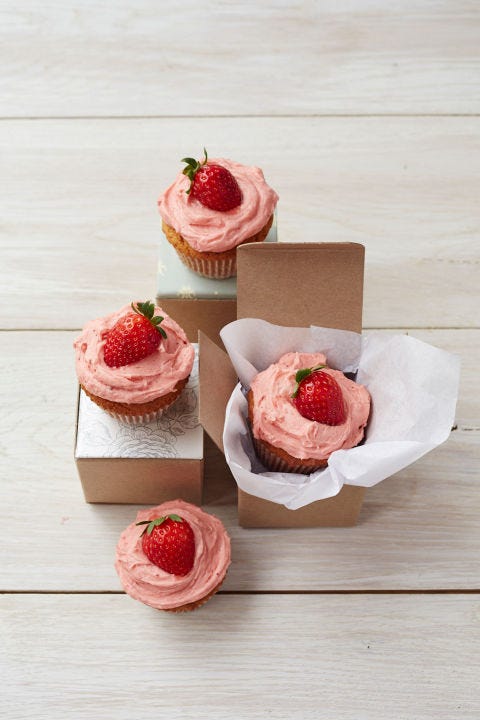 peanut butter and jelly cupcakes with pink frosting and strawberries on top