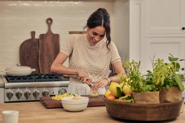 Person preparing food in a kitchen with fresh ingredients.