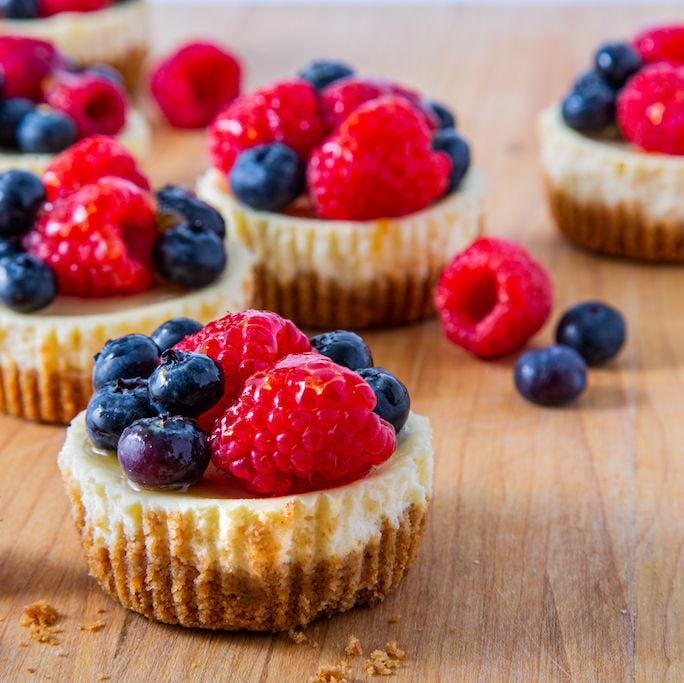 cheesecake cupcakes with mixed berries on top