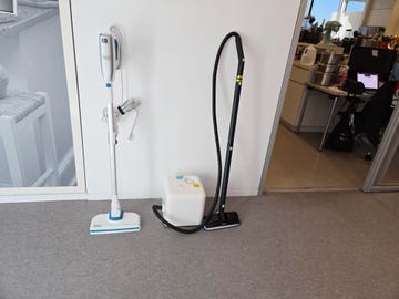 two household steam cleaning appliances on a carpeted floor