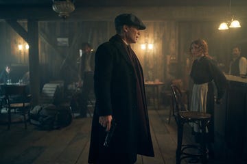 A tense scene in a dimly lit tavern with a man holding a gun.