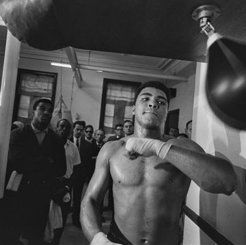 muhammad ali hitting a punching bag as people look on