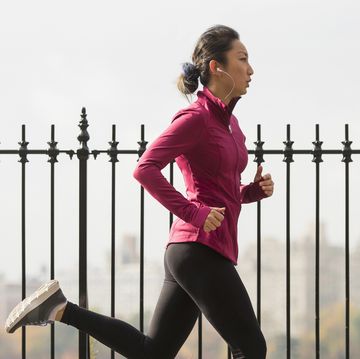 asian woman running on waterfront path