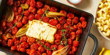 baked feta in a pan with roasted cherry tomatoes and shallots