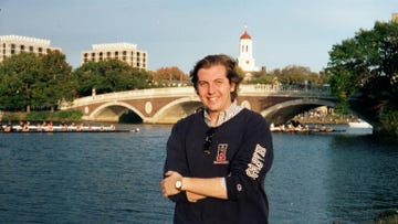 a man standing in front of a river and a bridge