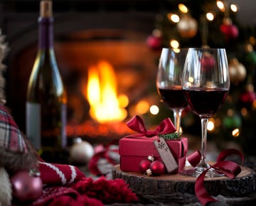 christmas red wine and a gift in front of a fireplace very shallow depth