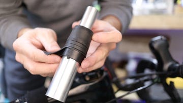 handling a metal cylindrical object with a black rubber grip