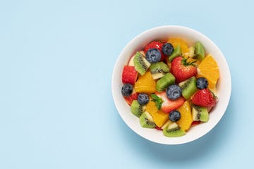 bowl with fruit salad on blue background