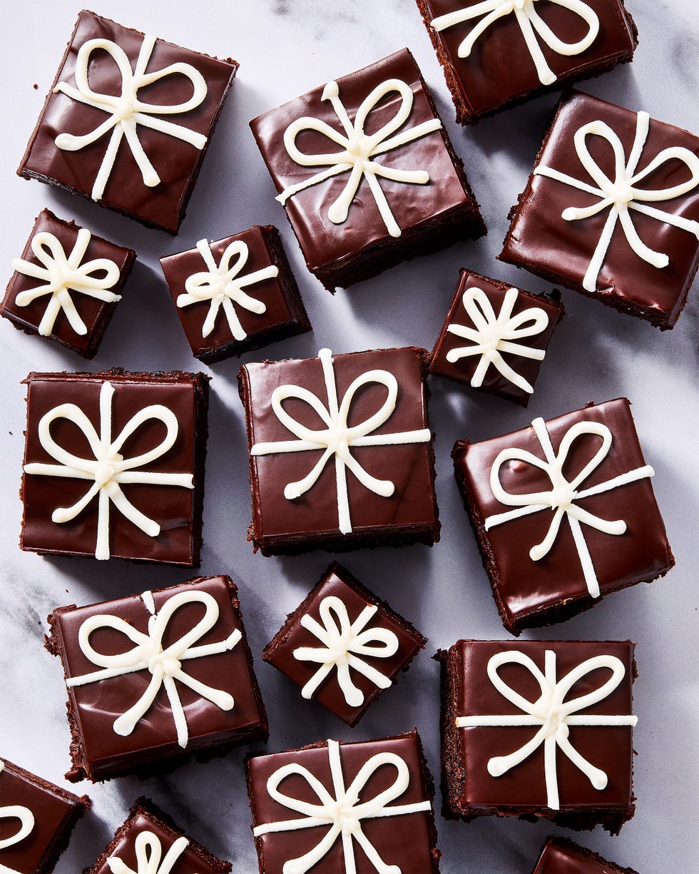 small brownies decorated with chocolate ganache and white icing to look like christmas presents